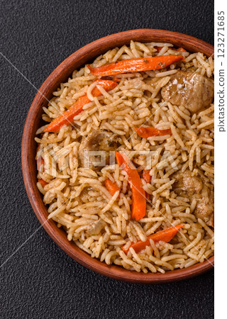 Delicious fresh pilaf with rice, carrots, meat, onions, spices and berries 123271685
