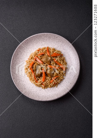 Delicious fresh pilaf with rice, carrots, meat, onions, spices and berries 123271688
