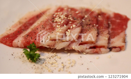 Slice of fresh beef or pork meat present in a white plate for grill, barbeque, and hot pot. Japanese Wagyu Yakiniku beef slice. 123271904