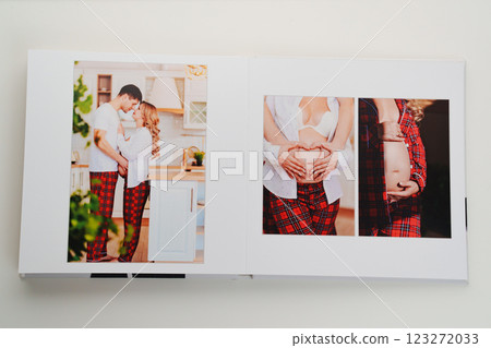 The pages of a photo book with color photos of a pregnant blonde and a man. The pages of a photo book with color photos of a pregnant blonde and a man. 123272033