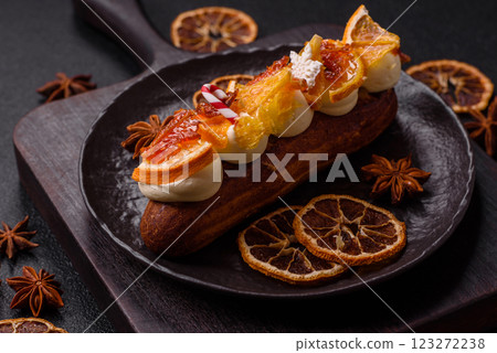 Delicious sweet eclair with chocolate filling, covered with cream Delicious sweet eclair with chocolate filling, covered with cream 123272238