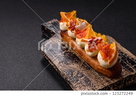 Delicious sweet eclair with chocolate filling, covered with cream Delicious sweet eclair with chocolate filling, covered with cream 123272249