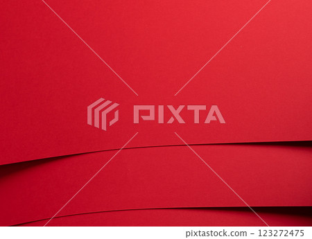 Bold scarlet red paper background with a deep matte texture and overlapping folds. Smooth geometric 123272475