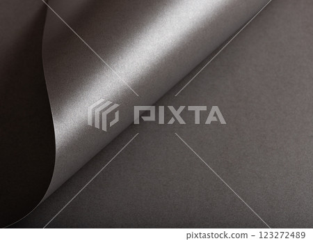 Charcoal gray paper background with a pearlescent, glossy texture and shimmering wavy edges. Deep Charcoal gray paper background with a pearlescent, glossy texture and shimmering wavy edges. Deep 123272489