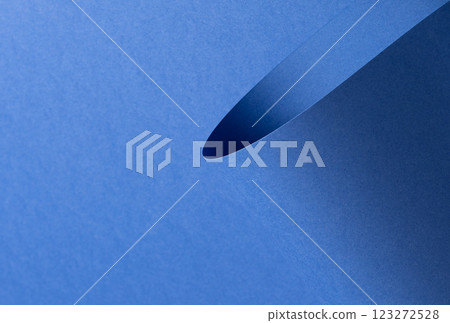 Deep sapphire blue paper background with a smooth texture and overlapping curved folds. Vibrant 123272528