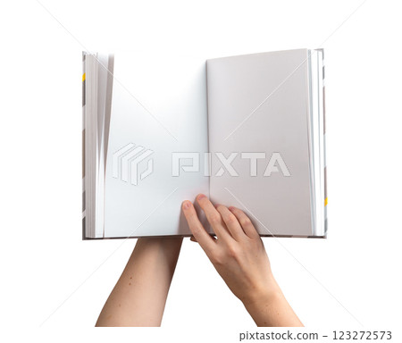holding an open, blank book or notebook with both hands, showcasing the clean pages for reading or holding an open, blank book or notebook with both hands, showcasing the clean pages for reading or 123272573