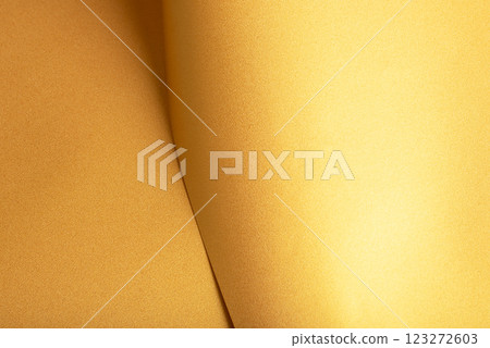 Golden saffron paper background with a pearlescent, glossy texture and shimmering folds. Rich Golden saffron paper background with a pearlescent, glossy texture and shimmering folds. Rich 123272603
