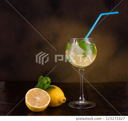 Summer drink with lemon and mint. Composition of drink and lemon. Glass with drink on the table. Summer drink with lemon and mint. Composition of drink and lemon. Glass with drink on the table. 123272827