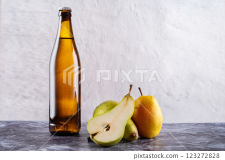Yellow glass bottle with drink. Bottle and fruit. Citro and pears. Sparkling water and pears. 123272828