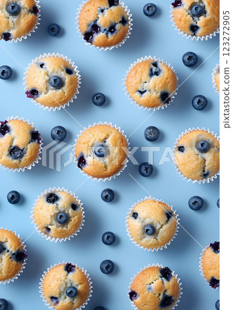 Enjoy the beautiful top view of homemade blueberry muffins with fresh blueberries on a soft pastel blue background. Ideal for those who love baking and indulging in delicious desserts Enjoy the beautiful top view of homemade blueberry muffins with fresh blueberries on a soft pastel blue background. Ideal for those who love baking and indulging in delicious desserts 123272905