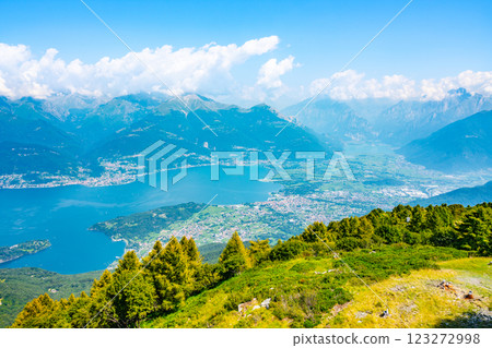 The breathtaking vista of Lake Como unfolds from the nearby hills, showcasing lush greenery, tranquil waters, and the majestic mountains surrounding this enchanting Italian destination. 123272998