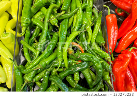 A vibrant display of fresh green, red, and yellow chili peppers arranged in a grocery store A vibrant display of fresh green, red, and yellow chili peppers arranged in a grocery store 123273228