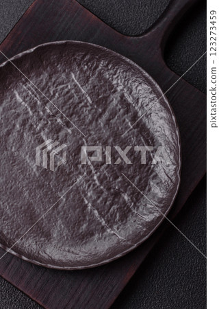 Empty black ceramic plate on a dark concrete background 123273459