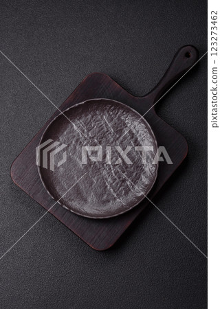 Empty black ceramic plate on a dark concrete background 123273462