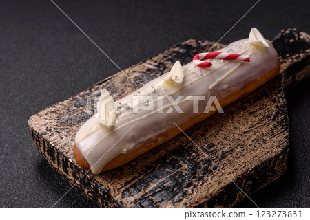 Sweet eclair with chocolate filling covered with white glaze Sweet eclair with chocolate filling covered with white glaze 123273831