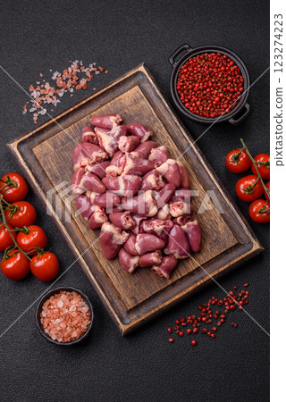Raw chicken hearts with salt, spices and herbs 123274223