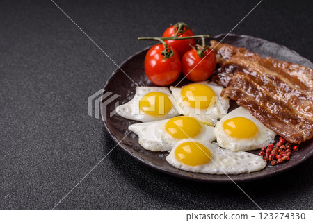 A hearty, delicious breakfast with fried eggs, bacon and tomatoes 123274330