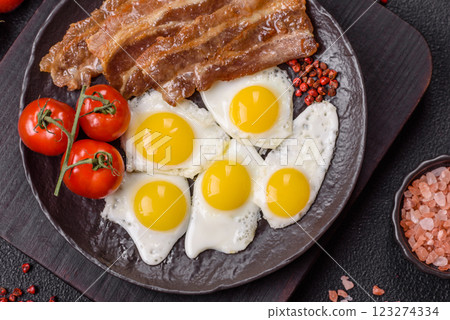 A hearty, delicious breakfast with fried eggs, bacon and tomatoes 123274334