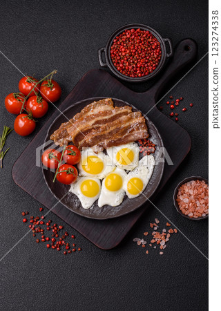 A hearty, delicious breakfast with fried eggs, bacon and tomatoes 123274338