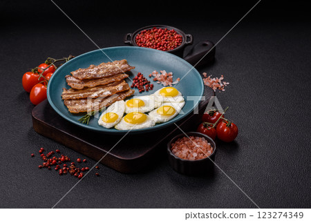 A hearty, delicious breakfast with fried eggs, bacon and tomatoes A hearty, delicious breakfast with fried eggs, bacon and tomatoes 123274349