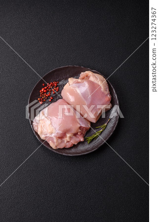 Fresh raw chicken thigh fillets with salt, spices and herbs Fresh raw chicken thigh fillets with salt, spices and herbs 123274367