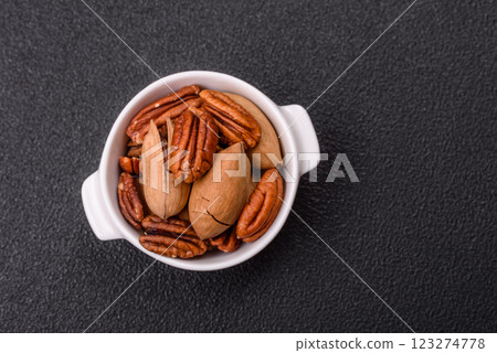 Delicious nutritious pecan nuts in ceramic bowl Delicious nutritious pecan nuts in ceramic bowl 123274778