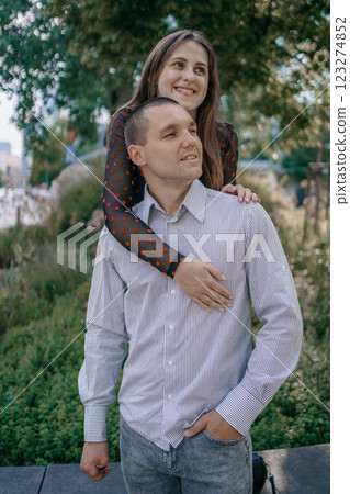 Happy couple in love enjoying a playful moment in the city park. A young man sitting on a bench holding his girlfriend in his arms as they smile at each other. Urban nature, romance, and joy. Happy couple in love enjoying a playful moment in the city park. A young man sitting on a bench holding his girlfriend in his arms as they smile at each other. Urban nature, romance, and joy. 123274852