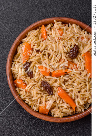 Delicious fresh pilaf with rice, carrots, meat, onions, spices and berries Delicious fresh pilaf with rice, carrots, meat, onions, spices and berries 123275113