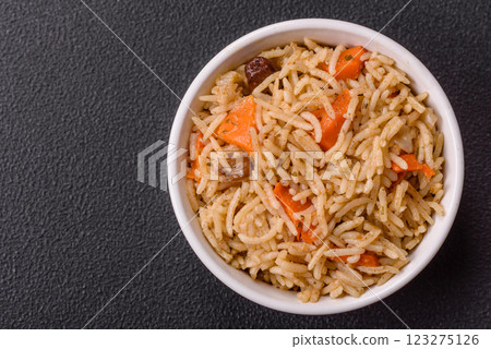 Delicious fresh pilaf with rice, carrots, meat, onions, spices and berries Delicious fresh pilaf with rice, carrots, meat, onions, spices and berries 123275126