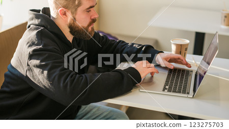 Close-up banner male guy portrait resting in coffee shop chatting in social networks skilled freelancer enjoying remote job typing publication for web blog on laptop copy space 123275703