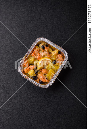Baked salmon pieces with potatoes, cheese and olives 123275771