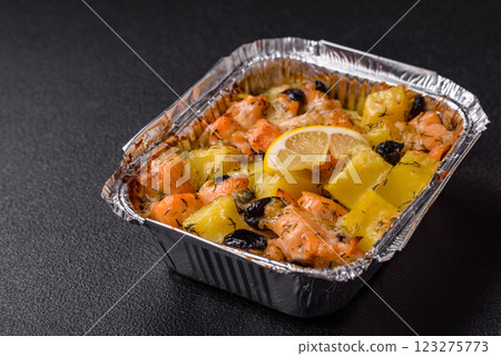 Baked salmon pieces with potatoes, cheese and olives 123275773