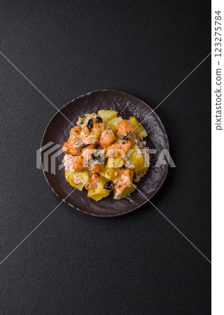 Baked salmon pieces with potatoes, cheese and olives Baked salmon pieces with potatoes, cheese and olives 123275784
