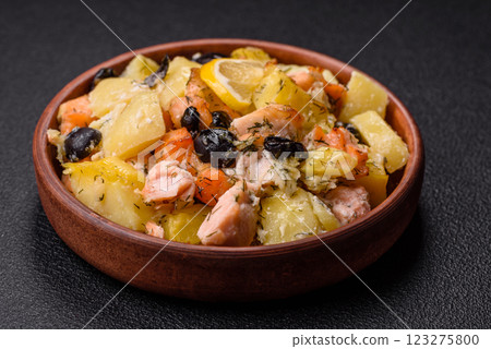 Baked salmon pieces with potatoes, cheese and olives 123275800