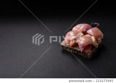 Fresh raw chicken thigh fillets with salt, spices and herbs Fresh raw chicken thigh fillets with salt, spices and herbs 123275845