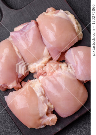 Fresh raw chicken thigh fillets with salt, spices and herbs Fresh raw chicken thigh fillets with salt, spices and herbs 123275866