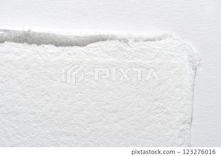 Close-up of textured white paper edge with subtle shadow on light background Close-up of textured white paper edge with subtle shadow on light background 123276016
