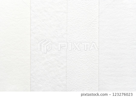 Close-up of textured white paper sheets with various patterns and subtle 123276023