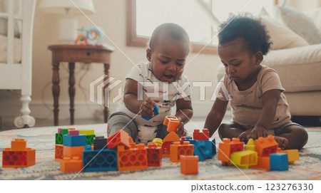 Two adorable toddlers playing with colorful building blocks on carpet, engaged in early childhood development through creative play in warm home setting 123276330