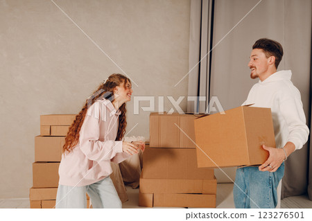 Happy young family couple man and woman moving with cardboard boxes to new estate home apartment. 123276501