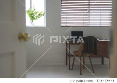 A room with a desk and a laptop 123276673