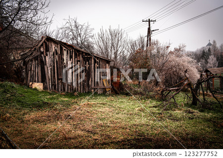 a wooden house in the garden is falling apart from old age. a wooden house in the garden is falling apart from old age. 123277752