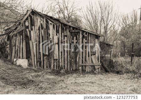 a wooden house in the garden is falling apart from old age. 123277753