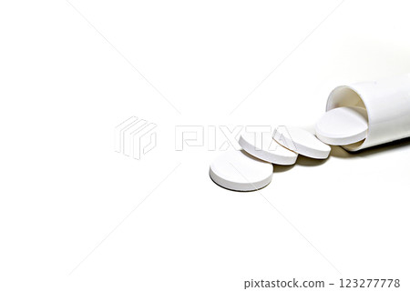 White medicine pills spilling out of a white bottle on white background. White medicine pills spilling out of a white bottle on white background. 123277778
