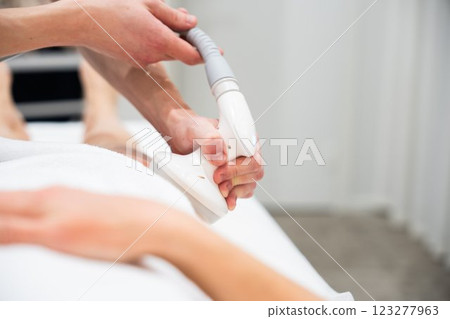 Wellness treatment in a spa with a therapist using a device 123277963