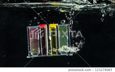 PH acid level test kit on quality water on screen. PH acid level tester kit tools fall under water splashing splattering with air bubble over black background isolated PH acid level test kit on quality water on screen. PH acid level tester kit tools fall under water splashing splattering with air bubble over black background isolated 123278065