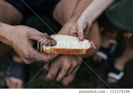 Child gives a homeless poor man a piece of bread in a modern capitalist society. Economic recession, unemployment, poverty, hunger, retirement, global crisis, the concept of the problem of inequality. Child gives a homeless poor man a piece of bread in a modern capitalist society. Economic recession, unemployment, poverty, hunger, retirement, global crisis, the concept of the problem of inequality. 123278106