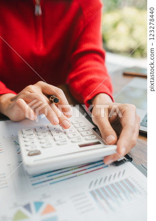 Close-up of hands using a calculator on financial documents, highlighting business analysis and accounting concepts. 123278440