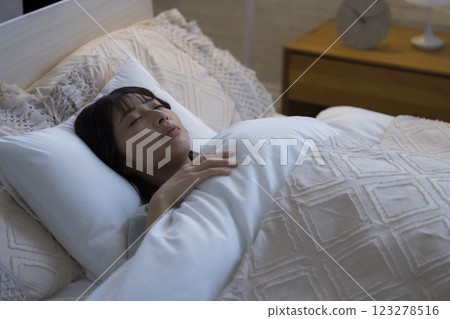 A young woman sleeping in bed 123278516