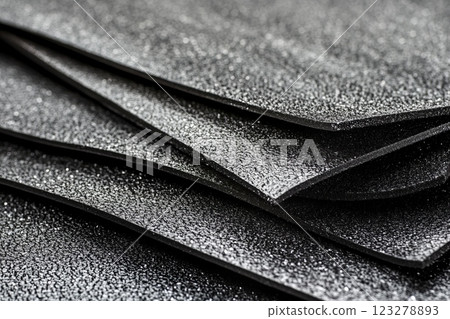 Roofing felt roll partially unrolled showing its inner layers, lying on a roof surface ready for installation 123278893